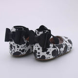 Children's boutique leather shoes.  Our cow print ballet style shoes have a black bow back.