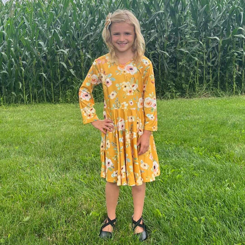 Gorgeous mustard dress with floral print from our exclusive girls boutique line.  Full twirlable skirt, with hidden pockets in the side seam.  Back features a criss-cross at neckline.