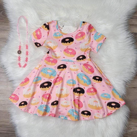 Girls boutique pink short sleeve dress with various colors frosted donuts throughout print..