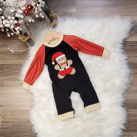 Children's boutique baby boy romper.  Black body with gingerbread boy dressed in Santa hat and overalls with a red bowtie.  Romper has striped red sleeves.  Snap closure.
