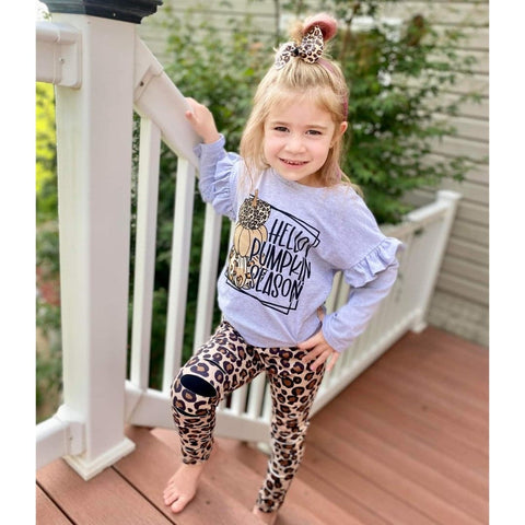 Girls boutique outfit with grey ruffle "Hello pumpkin season" top, paired with leopard print distressed and patched leggings.