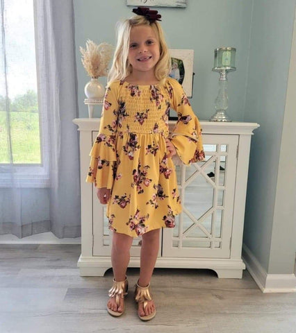 Girls boutique dress.  Yellow bell sleeve dress with smocked top feature, and floral print.